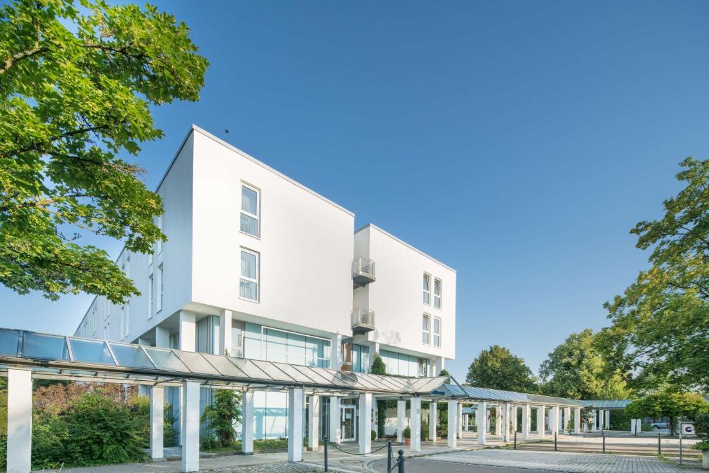 韦因加尔滕韦恩加顿贝斯特韦斯特公园酒店的一座白色建筑的图象,带有庭院