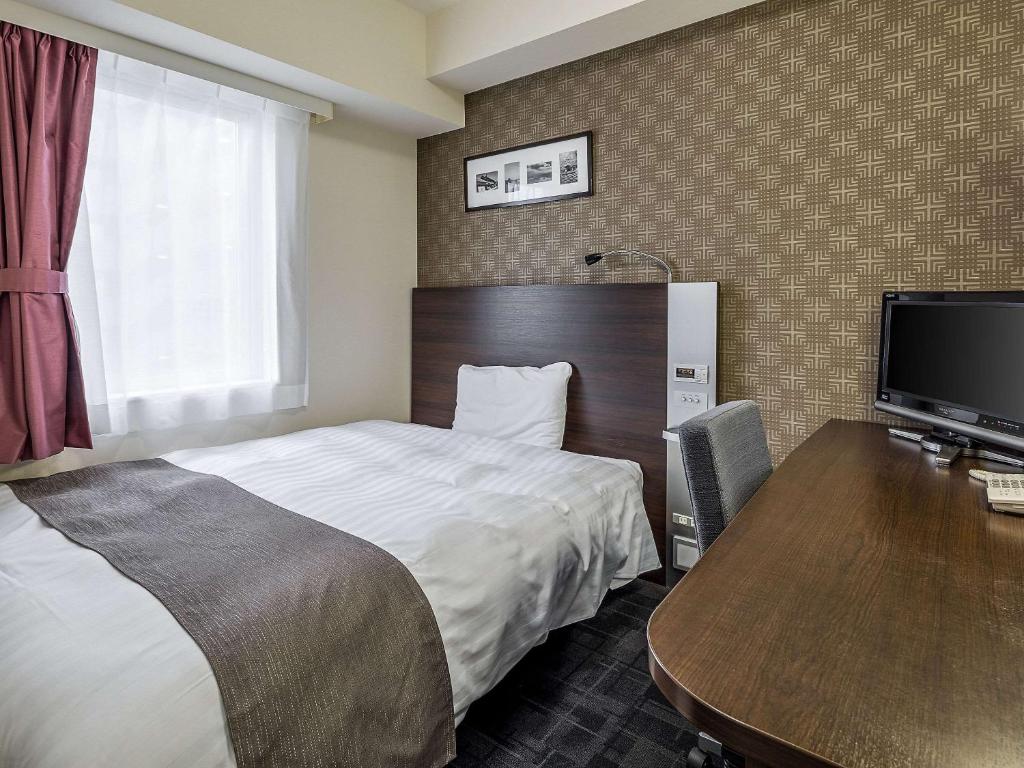 铃鹿市铃鹿酒店的酒店客房配有一张床和一张带电脑的书桌