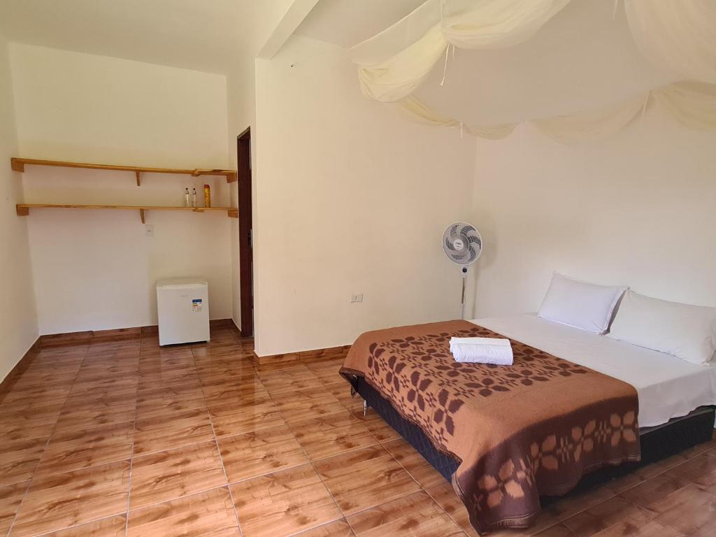 韦尔卡鲍Casa da Trilha的一间卧室配有一张床和风扇