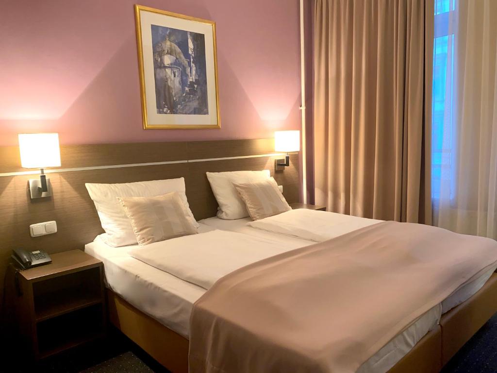 汉堡Hotel Hansehof的一间卧室配有一张带两盏灯的大型白色床。