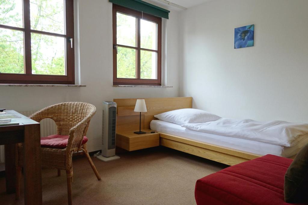 科隆海伦恩沃尔裴森酒店的一间卧室配有一张床、一张桌子和一把椅子