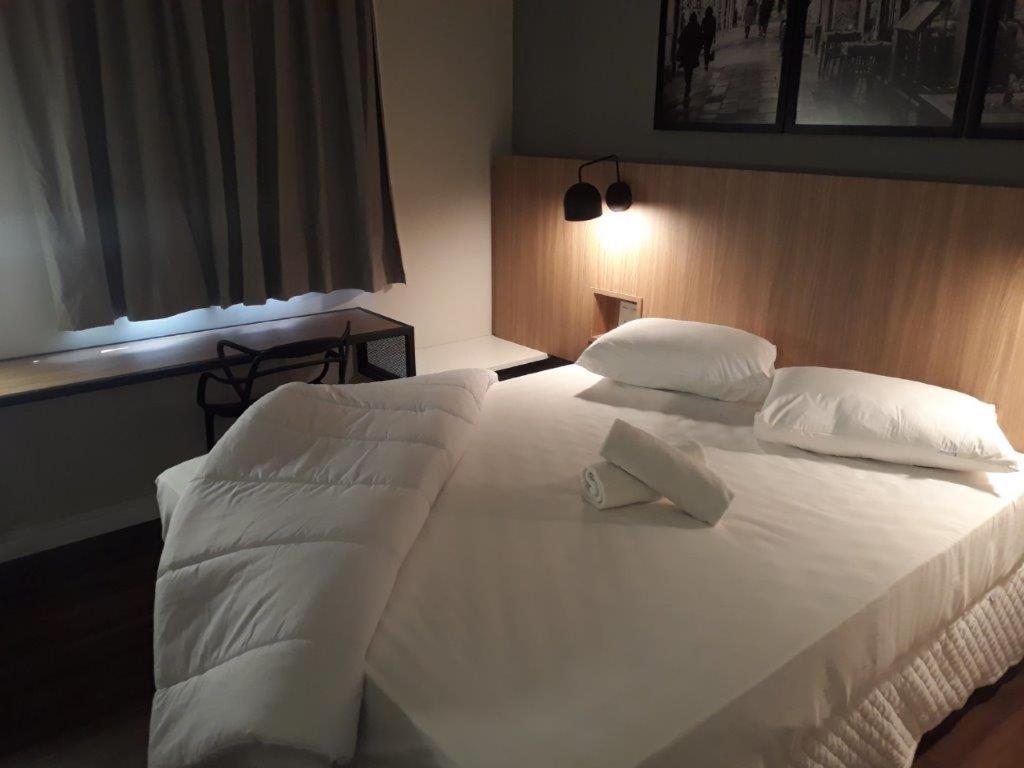 乌贝拉巴Graal Inn Uberaba的一张带两个枕头的大白色床