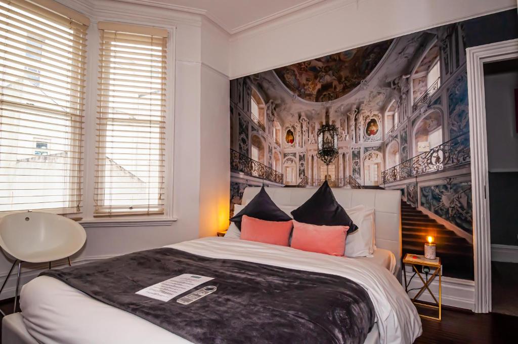 布莱顿霍夫Hotel Nineteen的卧室配有一张大床,墙上挂有绘画作品