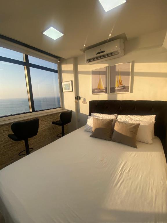 萨尔瓦多VITORIA MARINA Flat CORREDOR DA VITORIA的卧室设有一张大白色的床和大窗户