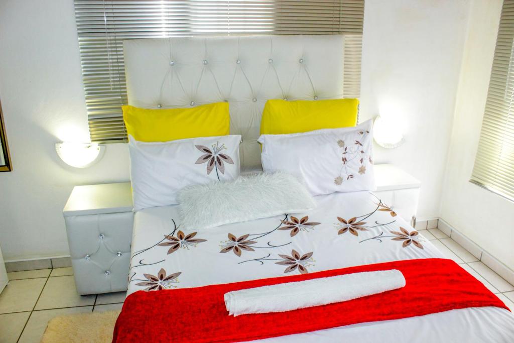 帕拉佩Motseleng Guest House的一张带红色毯子和枕头的白色床