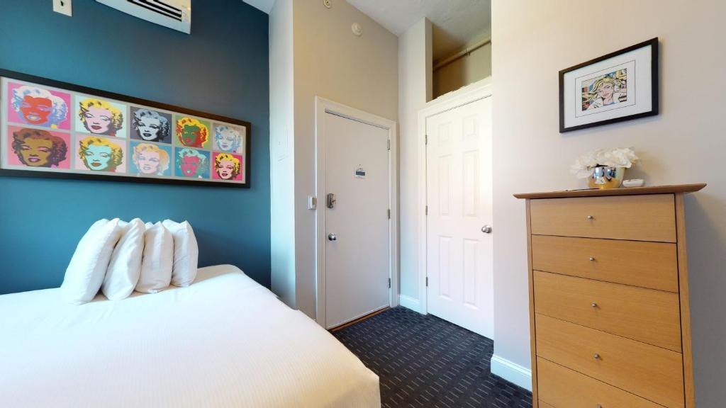 波士顿South End Studio Perfect for Work Travel #26的卧室配有白色的床和蓝色的墙壁