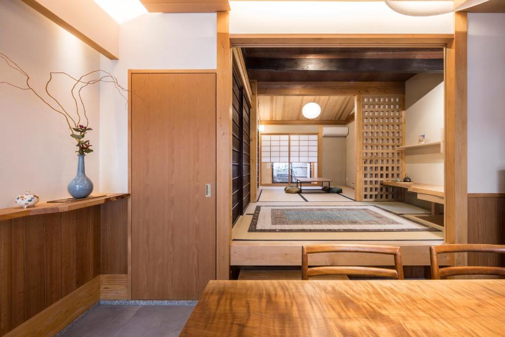 京都京町家套房利休的一间带桌椅的用餐室和一间带客房的房间