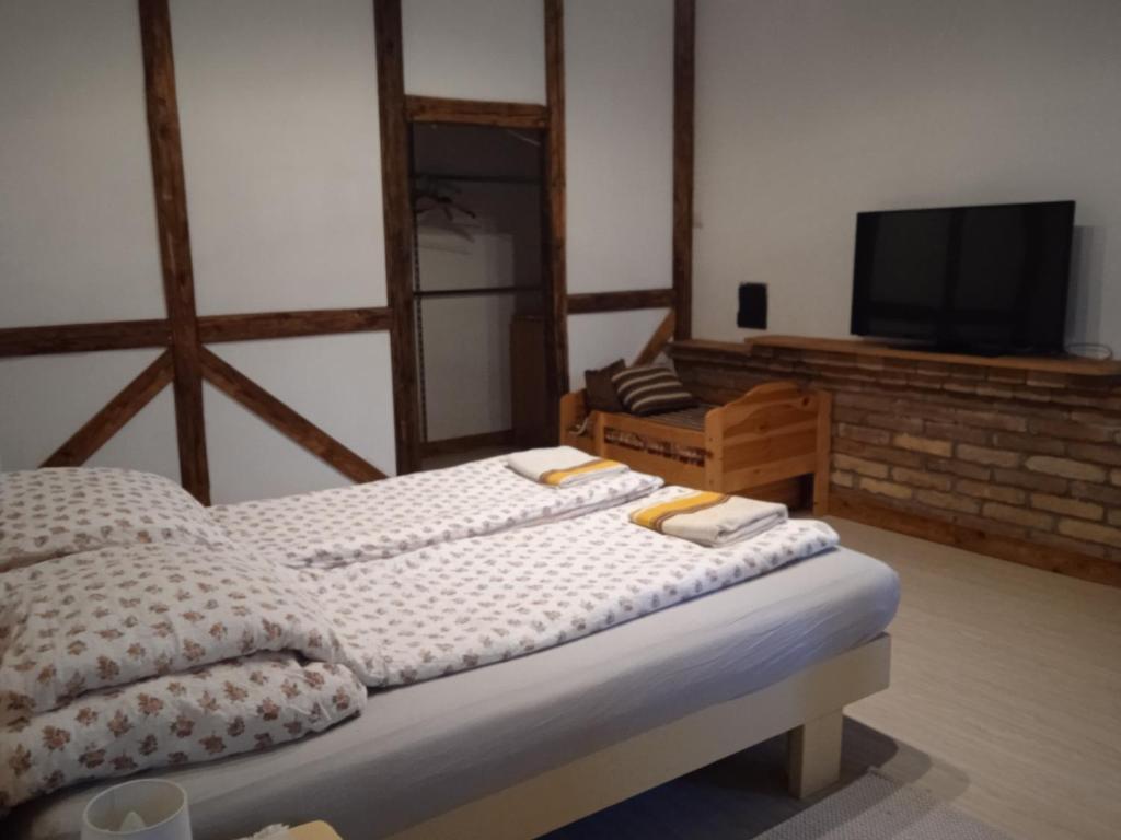 KismarosVeranda Vendégház的一间卧室配有一张床和一台电视。