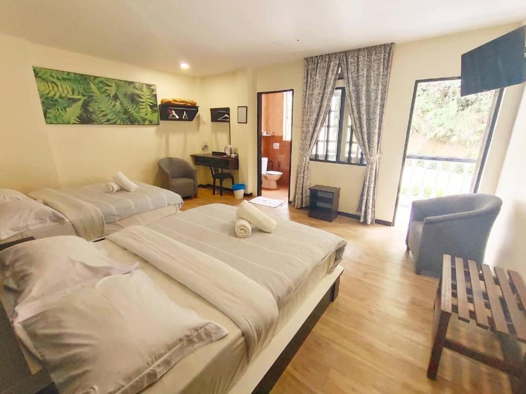 丹那拉打Hillview Inn Cameron Highlands PROMO的酒店客房配有两张床和一张书桌