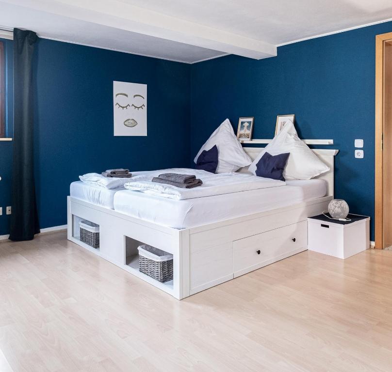 埃森Ferienwohnung mit Kuschelflair的一张白色的大床,位于一个蓝色的墙壁上