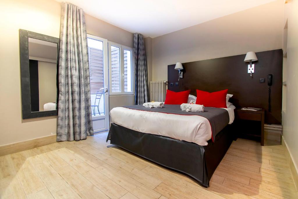 巴黎蒙马特歌剧院米尼酒店的一间卧室配有一张带红色枕头的大床