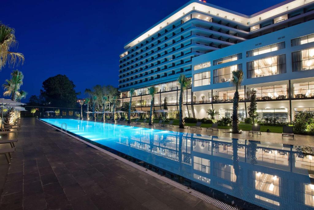 特拉布宗华美达广场酒店及spa中心特拉布宗的一座晚上设有游泳池的建筑