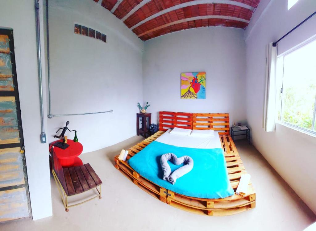 新利马Pousada Vila da Serra - Quarto do Amor的一间卧室配有一张床和一张红色椅子