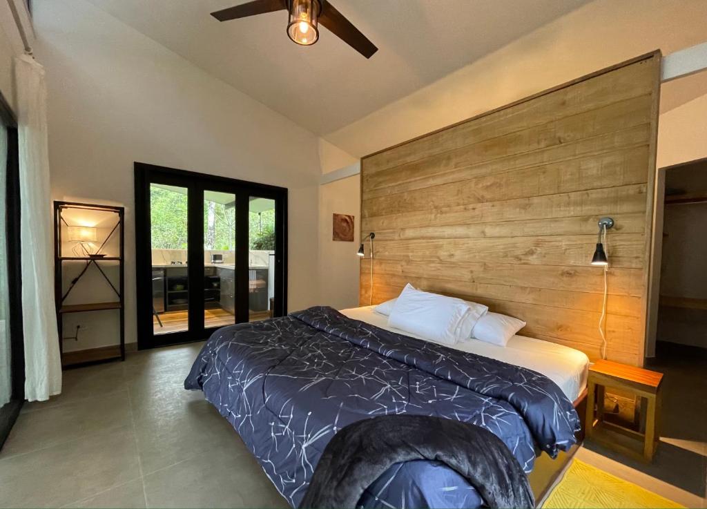 多米尼克Tree of Life Cabinas的一间卧室配有一张大床和木制床头板