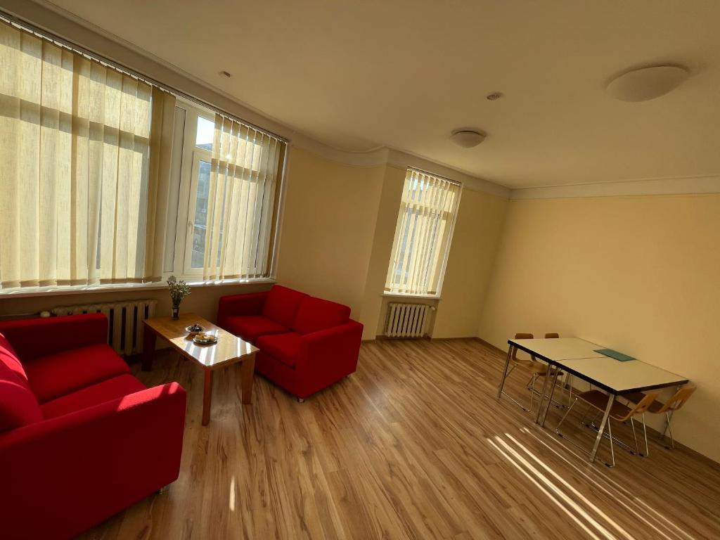 考纳斯Mr Jo’s hostel的客厅配有红色的沙发和桌子