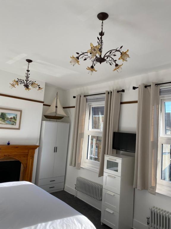 拉姆斯盖特Cosy 2 Bedroom House -2022 & 2023 Award Winner!的一间卧室配有一张床、吊灯和窗户。