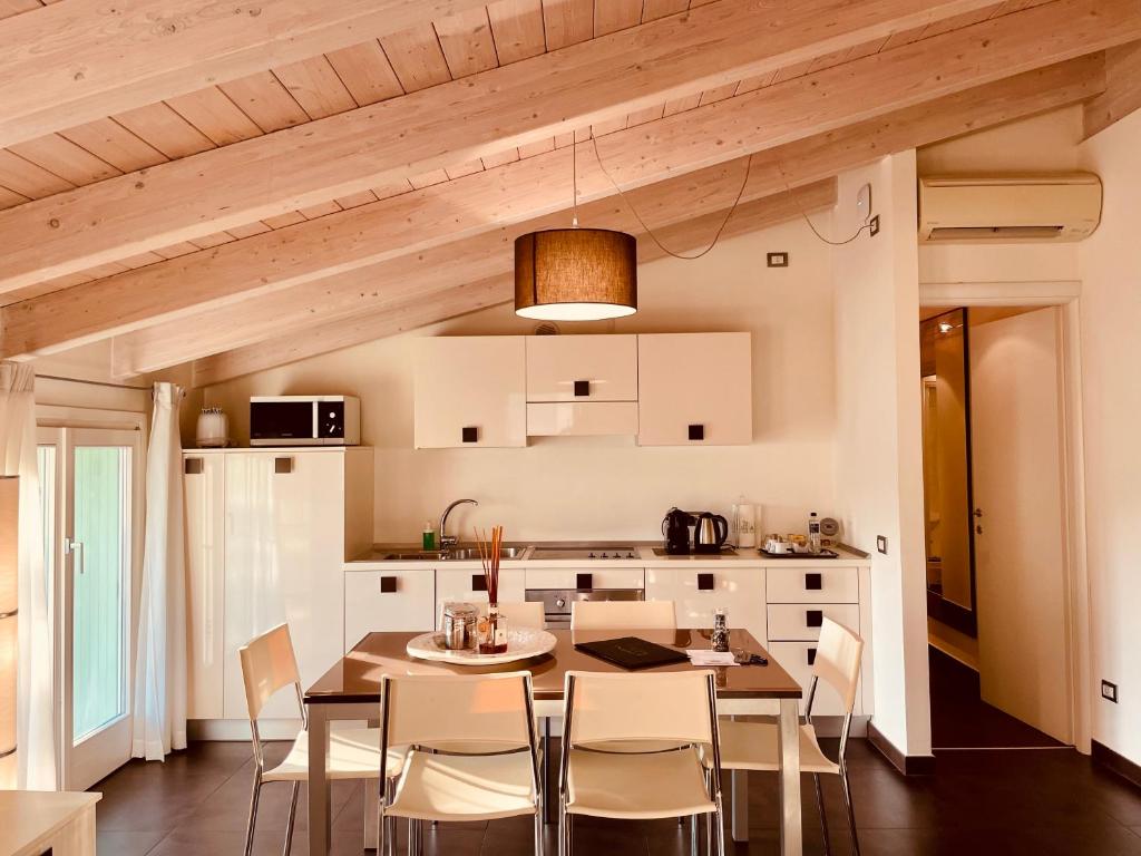 代森扎诺-德尔加达Residence Del Lago的厨房以及带桌椅的用餐室。
