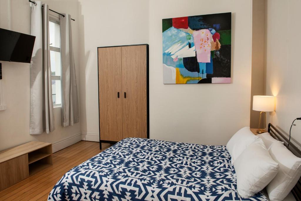 土乌巴The Met Hotel的卧室配有蓝色和白色的床以及橱柜。