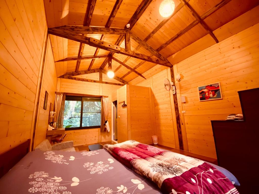 Leye金皮雕工作室的木制客房内的一间卧室,配有一张床