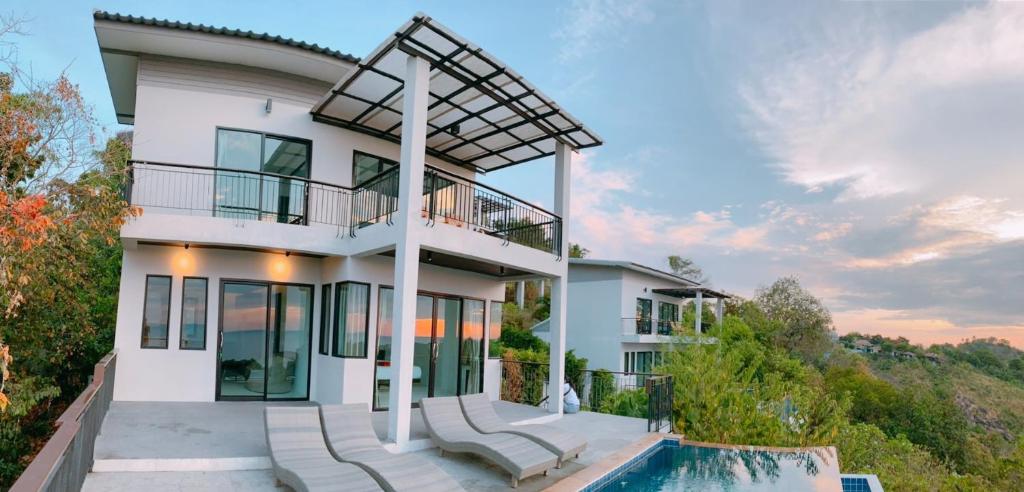沙拉海滩High Life Villas的一座白色的房子,前面设有一个游泳池