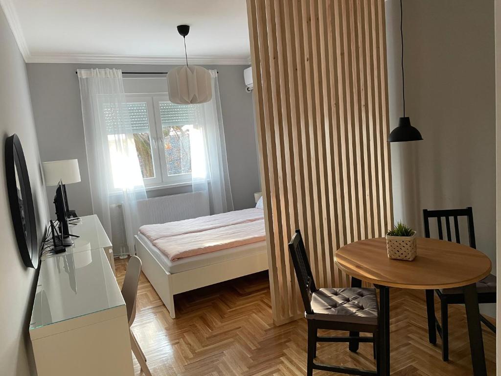 松博尔Apartmani Sombor的小房间设有小桌子和床