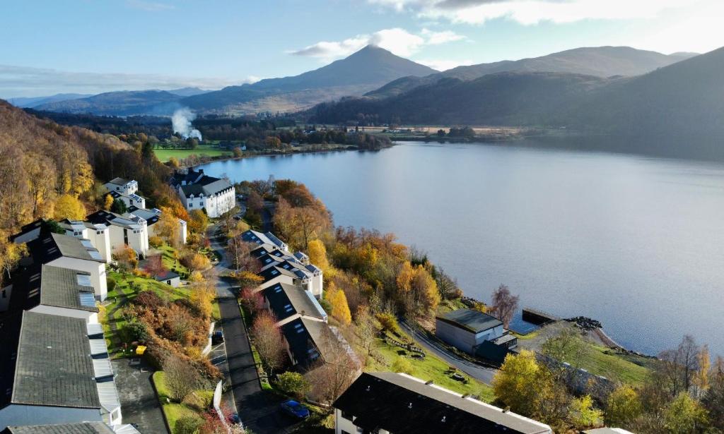 金洛赫兰诺赫Loch Rannoch Highland Club的享有湖泊的空中美景,背景为山脉