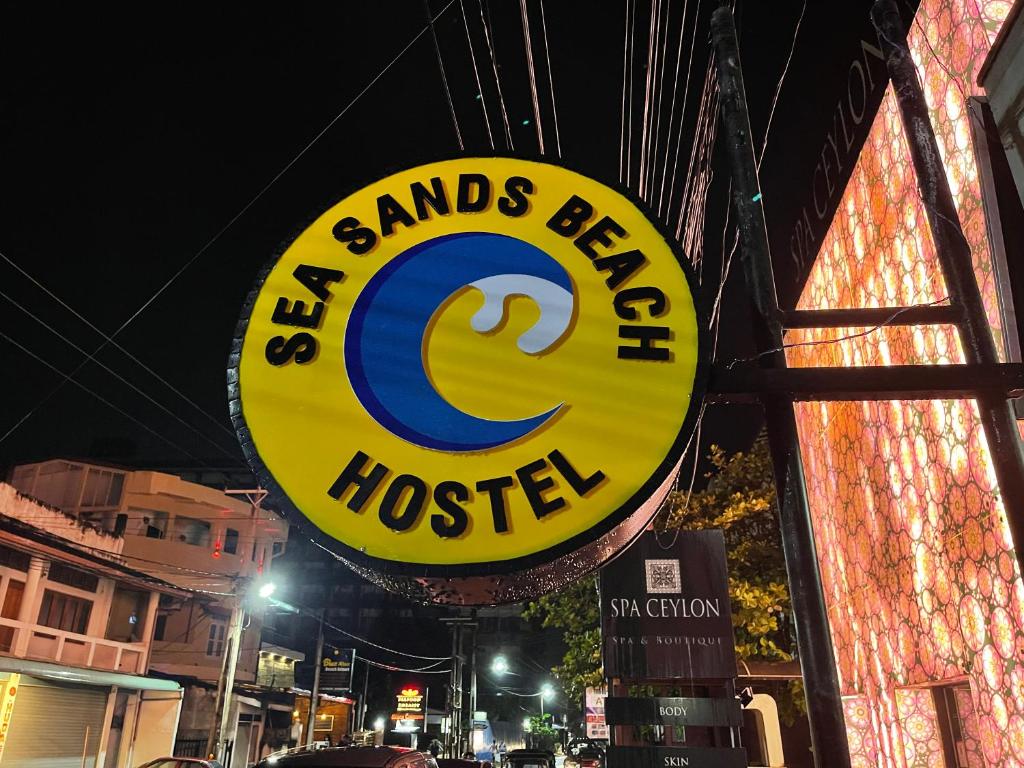 尼甘布Sea Sands Beach Hostel的桑托斯酒吧和旅馆标志