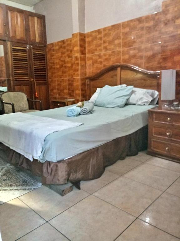 圣安娜Casa Blanca Tu Casa的一间卧室配有一张大床和木制床头板