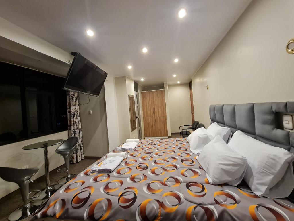 万卡约Hostal Tuki Huancayo的一间卧室配有一张大床和一台平面电视
