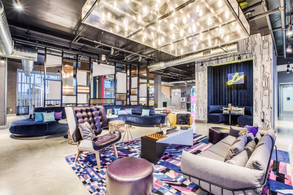 阿林顿Aloft Dallas Arlington Entertainment District的大楼内一个带沙发和椅子的大堂