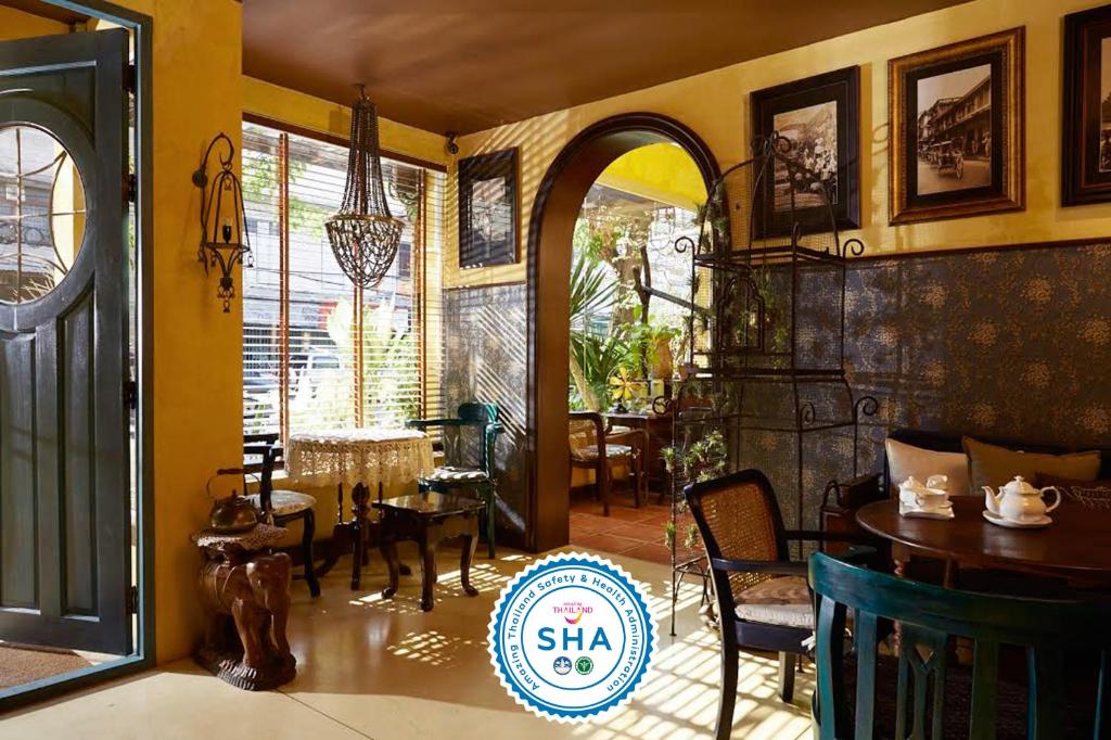 曼谷Old Capital Bike Inn - SHA Certified的一间带桌椅的用餐室