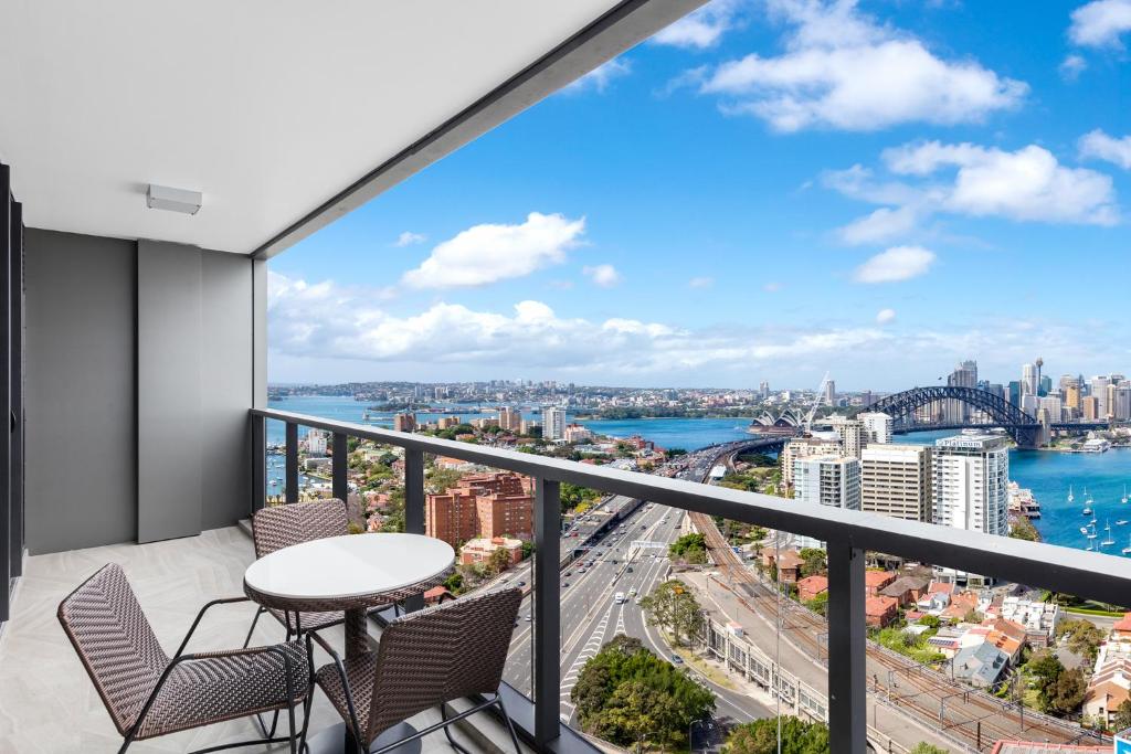 悉尼悉尼北部美利通公寓式酒店的市景阳台配有桌椅。