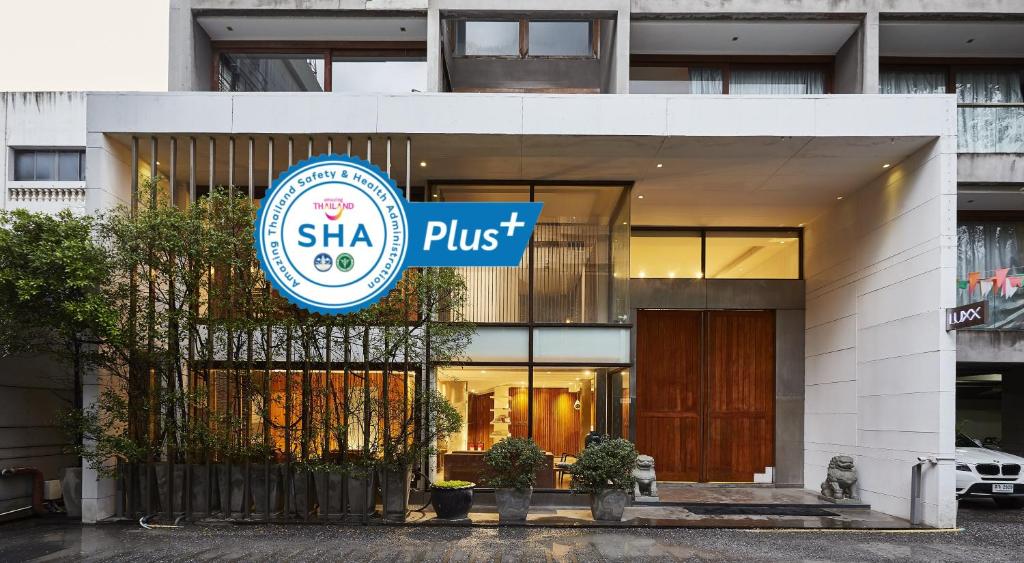 曼谷LUXX Langsuan Hotel - SHA Plus的带有读Shka+的标志的建筑