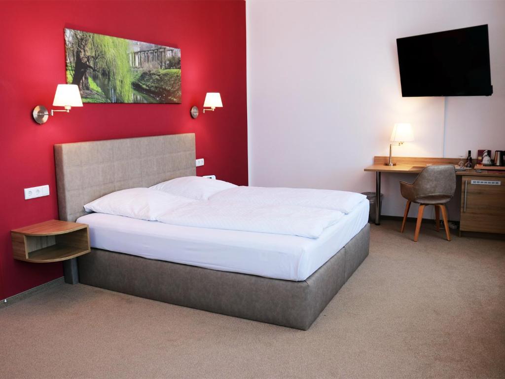 柏林维塔柏林展览馆酒店的一间卧室配有一张红色墙壁的床