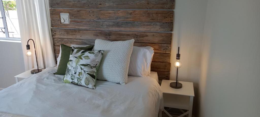东伦敦StayMore的一张带两个枕头的白色床和木制床头板