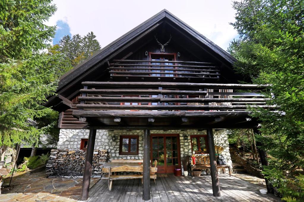 克拉尼斯卡戈拉Mountain Dreams House - Stunning view over Lake Jasna!的树林中的小木屋,设有大阳台