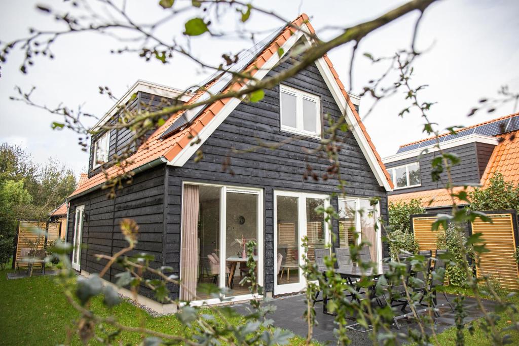 德科赫Het Mienterbos的一座带黑色 ⁇ 子和庭院的房子