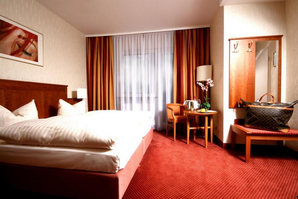 曼海姆魏格纳酒店的配有一张床和一张书桌的酒店客房