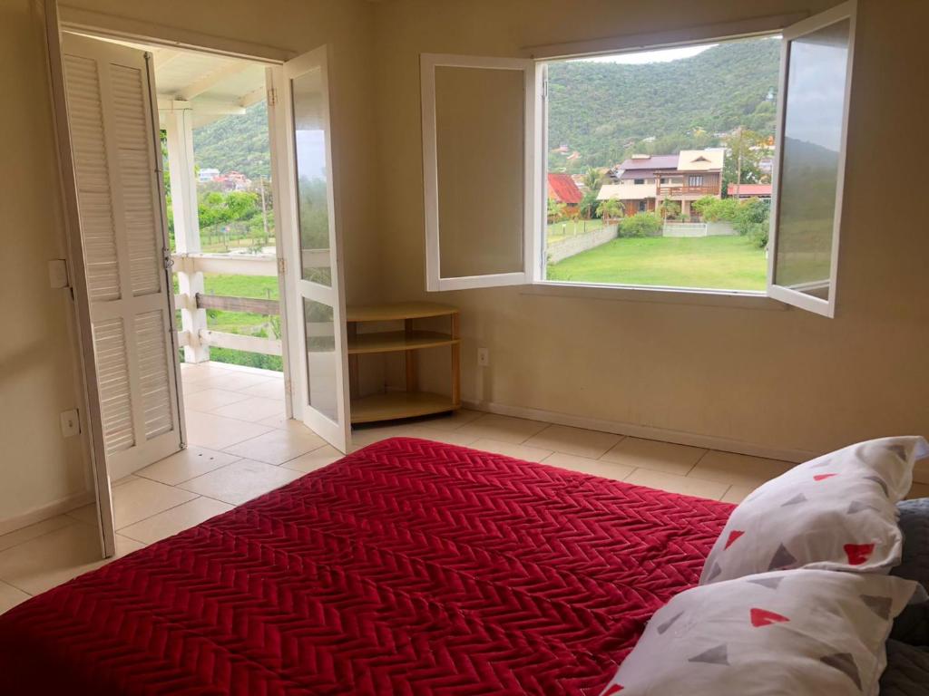 加罗帕巴Casa grande na Gamboa Garopaba的一间卧室设有一张床和一个大窗户