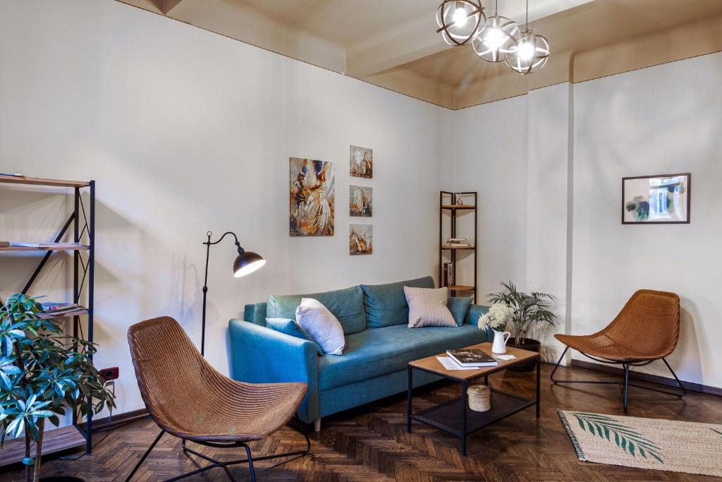 布加勒斯特Sweet Dreams Suites Piata Romana的客厅配有蓝色的沙发和椅子