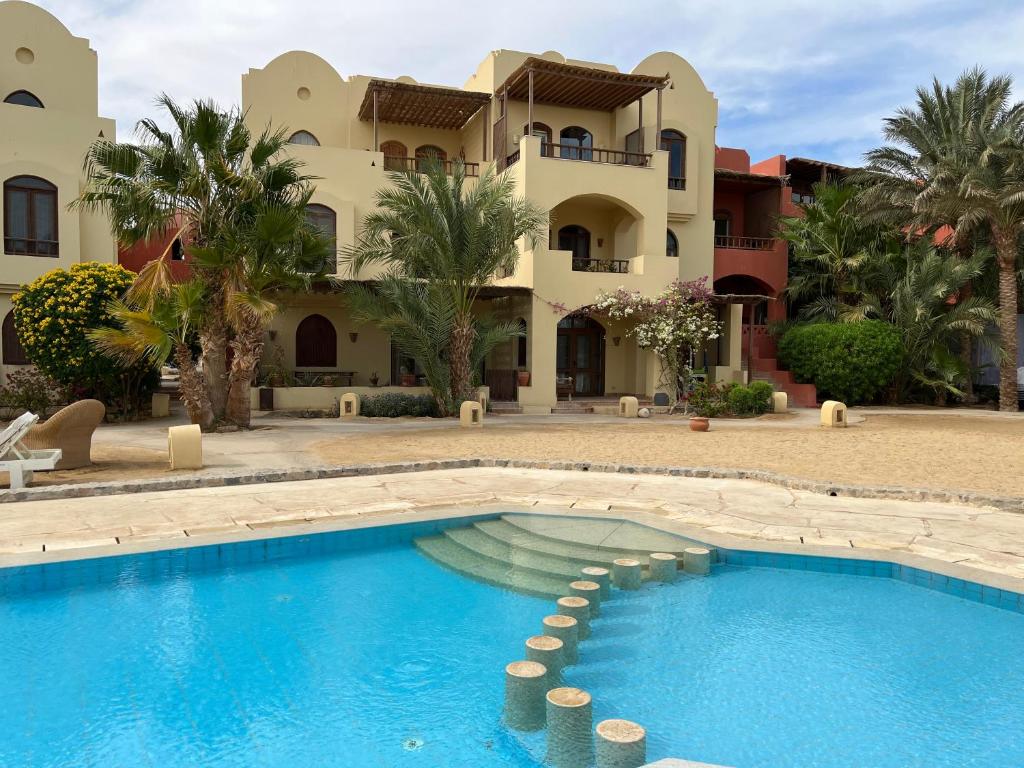 赫尔格达El Gouna, Red Sea, Egypt, West Golf 2 Bedroom Flat的一座带游泳池的度假村,位于一座建筑前