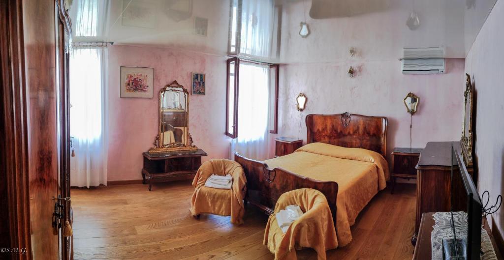 威尼斯Ca' degli Artisti的一间卧室配有一张床、一张桌子和一面镜子