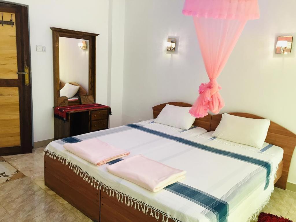 康提Kandy IVY Banks Holiday Resort的一间卧室配有带粉红色毛巾的床