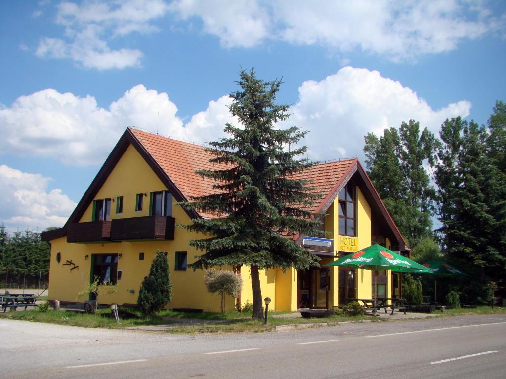 Dlouhá BrtniceRestaurace penzion Rafael的前面有一棵树的黄色房子