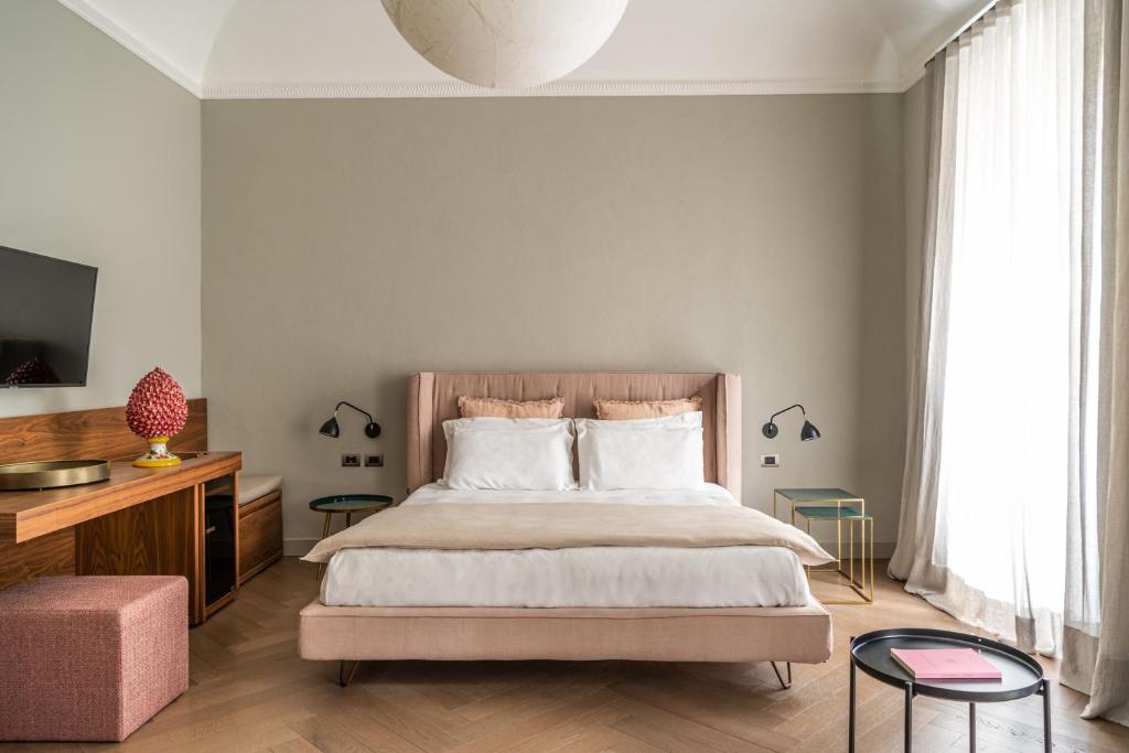 巴勒莫InCanto的一间卧室配有一张床、一台电视和一张沙发