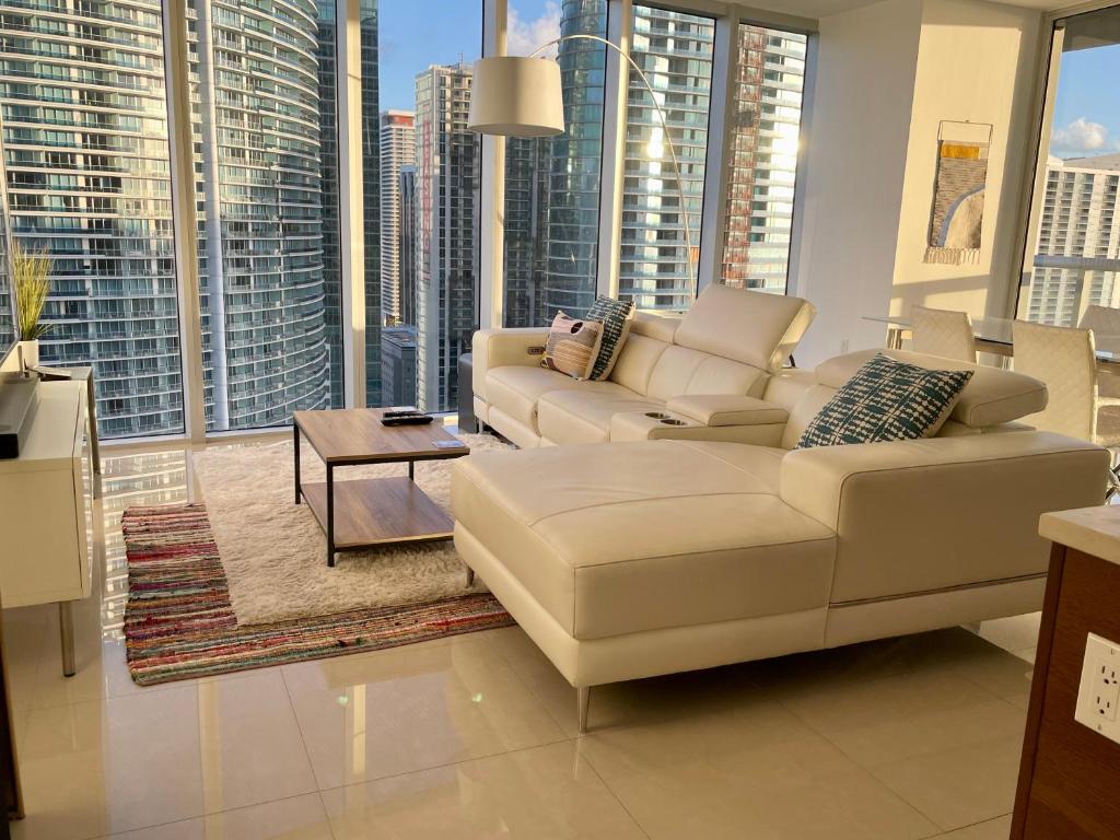 迈阿密IconBrickell Tower 3 W Residences的带沙发和桌子的客厅以及大窗户。