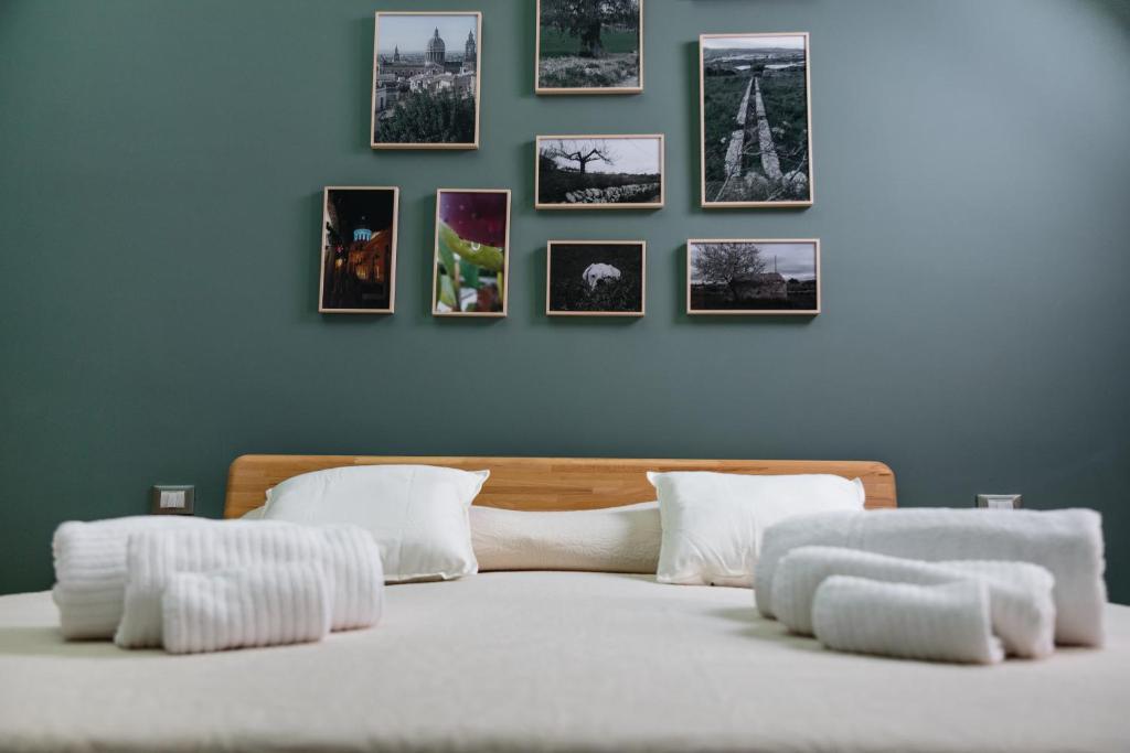 科米索B&B Giardinello的卧室配有一张墙上挂有照片的床