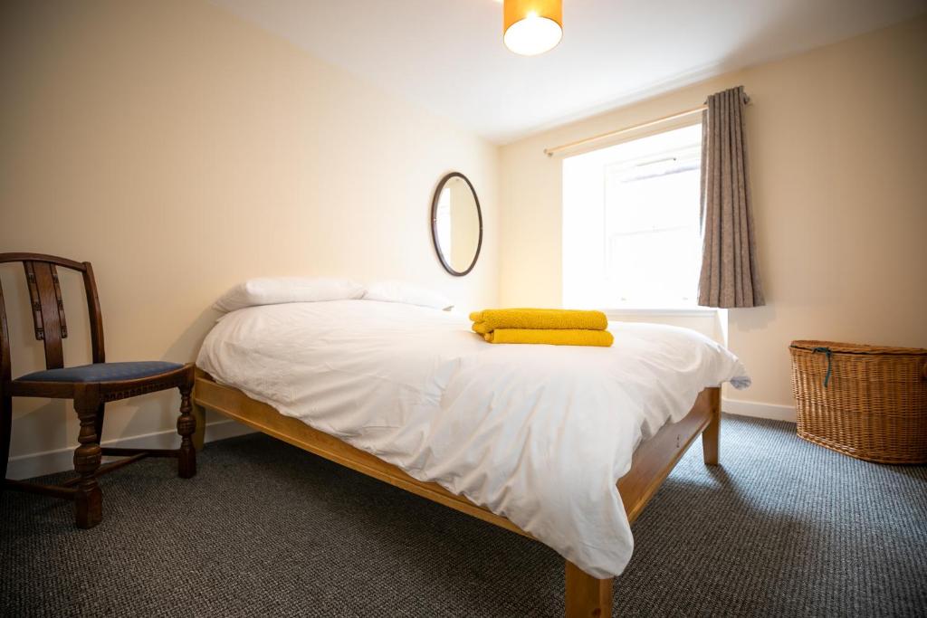 基里缪尔The Starry Rock的一间卧室配有一张黄色毛巾的床