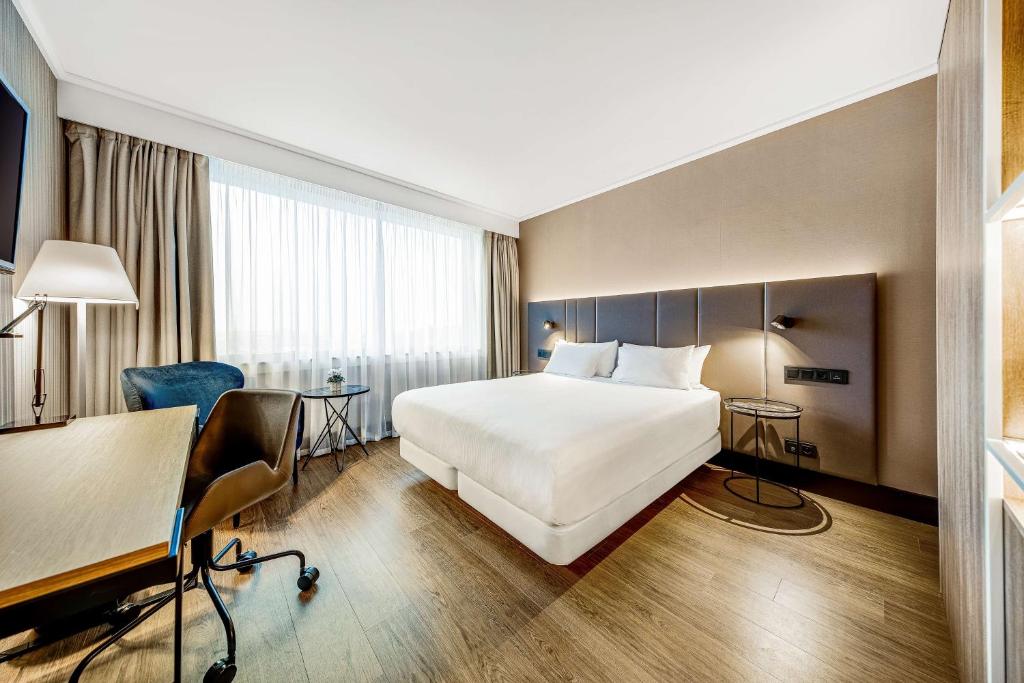 迭戈姆NH布鲁塞尔机场酒店的配有一张床和一张书桌的酒店客房
