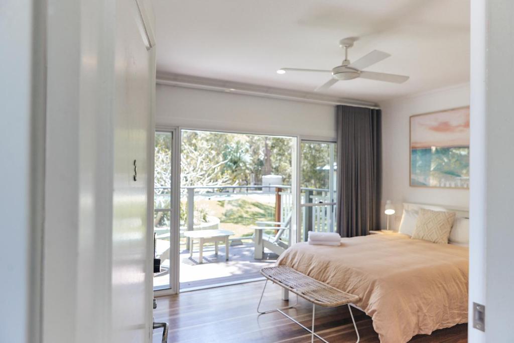 拜伦湾Sunrise Guesthouse的一间卧室配有一张床,享有庭院的景色